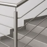 Barandilla metálica de acero inoxidable en escalera con baldosas grises